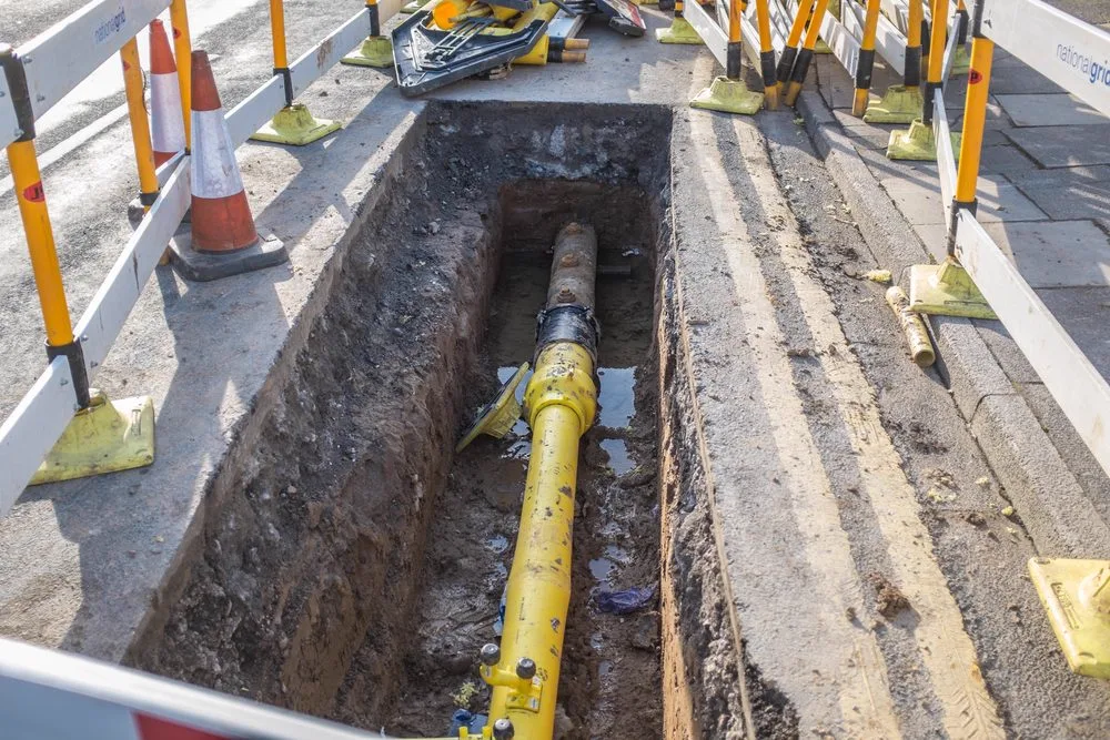 Long channel drain trench cut through a paved surface ready for install