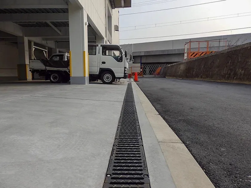Grated channel drain running along a commercial driveway in Brisbane